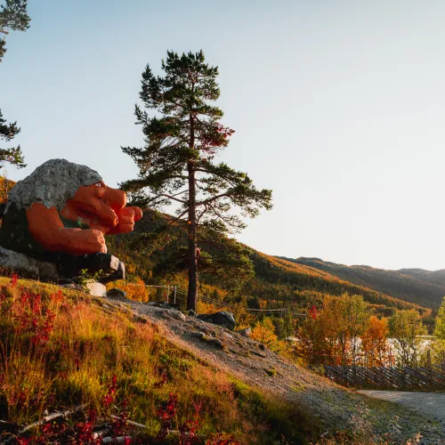 Rundt Ustedalsfjorden kan du lese informasjonsskilt og møte denne kjempetrollen som peker mot nasjonalpark Hallingskarvet