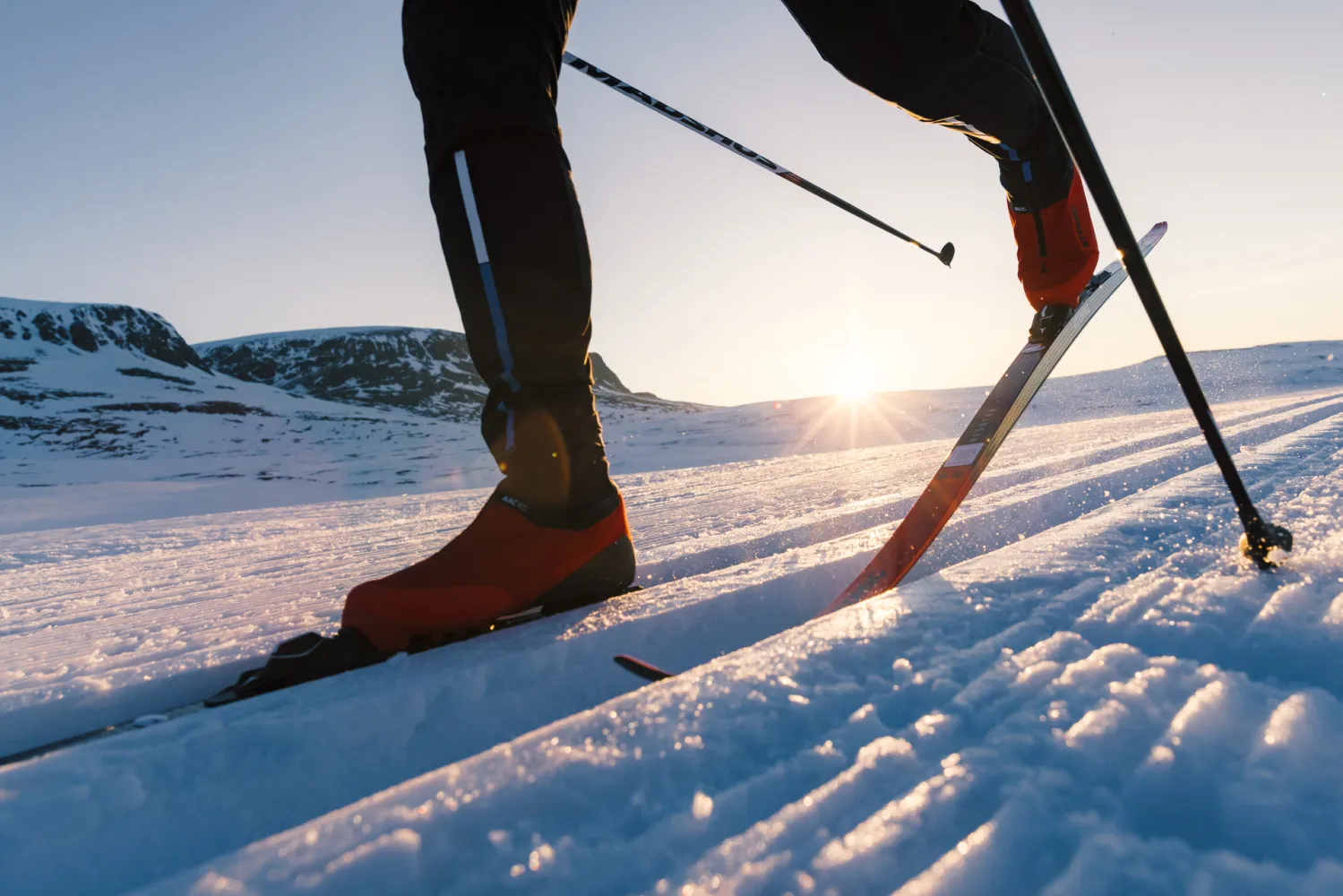 Langrennstur i solnedgang skidetaljer