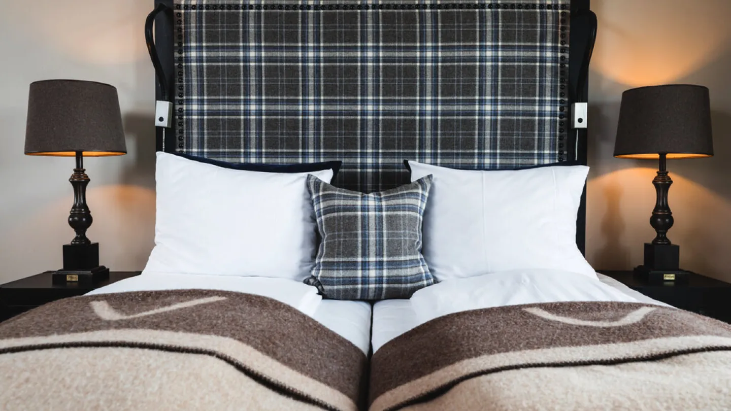 Overnatting hotell oppredd seng med pynteputer